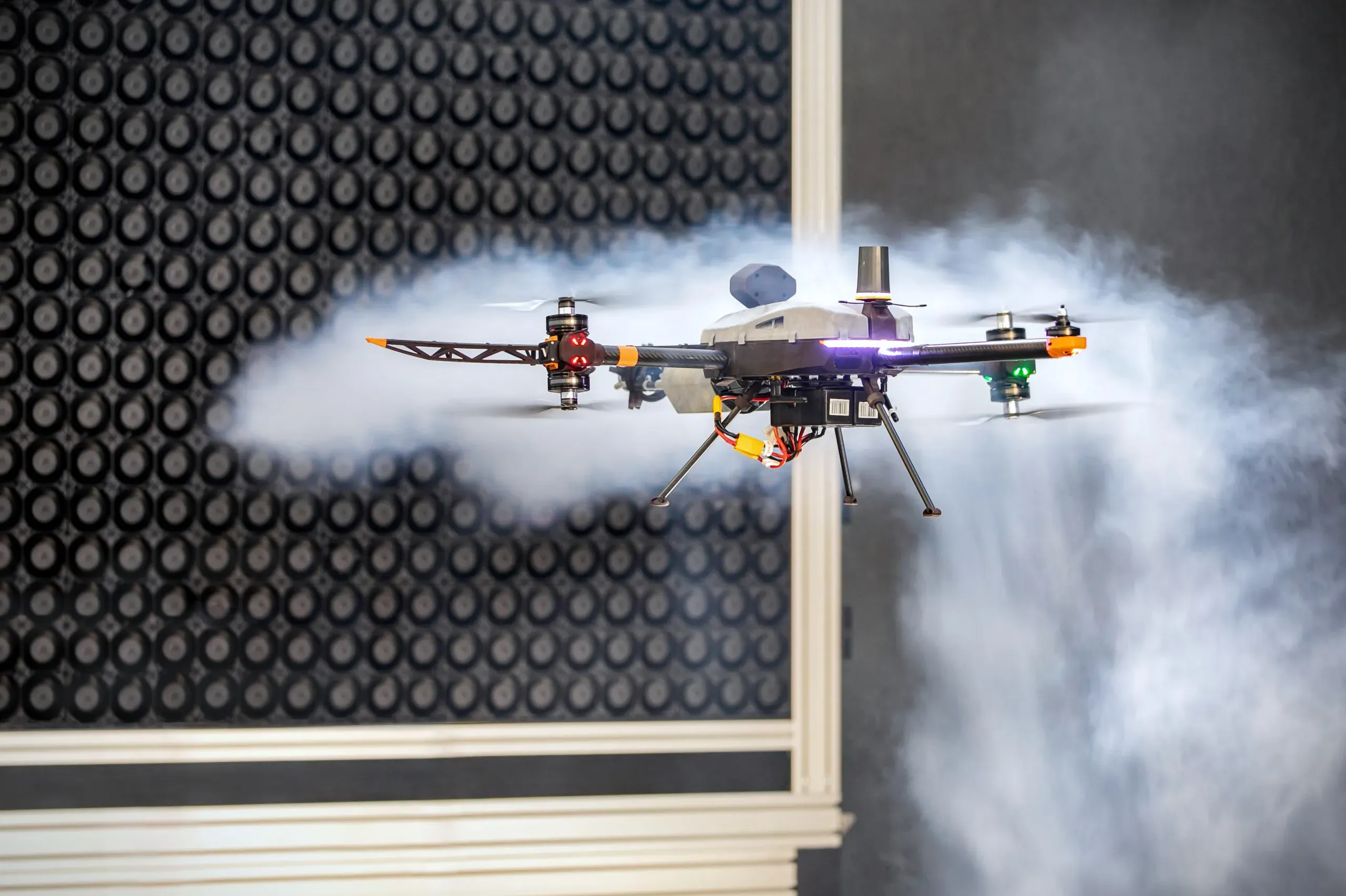 Multicopter drone performing a free flight test in a WindhSaper laboratory environment.